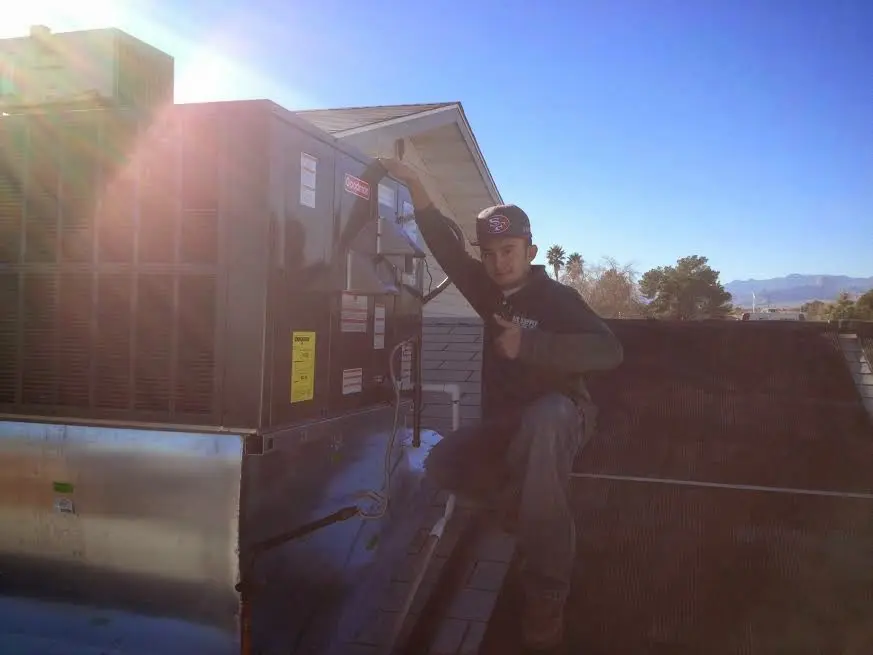HVAC technician performing Boiler Repair on a rooftop unit in Bethany